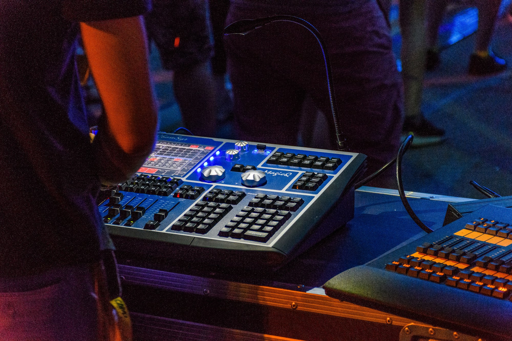 Rear view of sound guy behind mixing table at a concert.