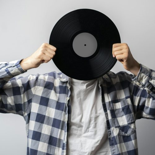 holding vinyl record disc in front of head