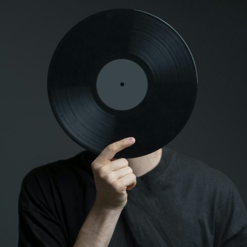 holding vinyl record disc in front of head